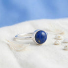 [KI] Silberring mit Lapislazuli auf hellem Stoff