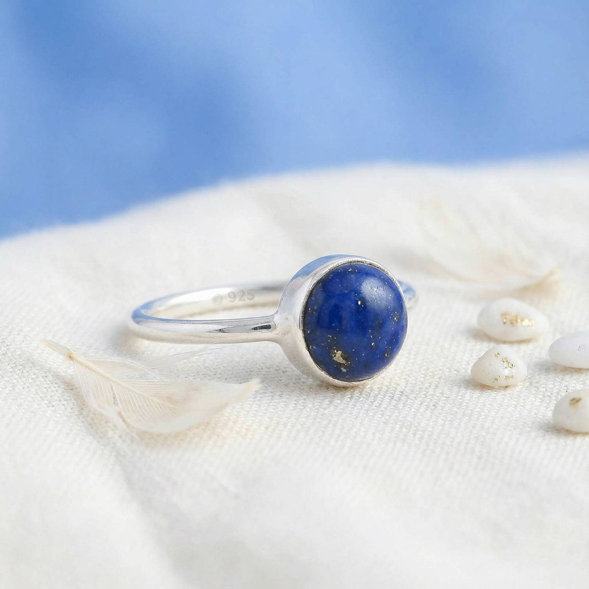 Silberring mit Lapislazuli auf hellem Stoff
