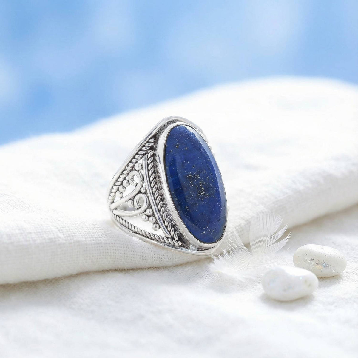 Silberring mit Lapislazuli auf hellem Stoff