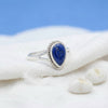 [KI] Silberring mit Lapislazuli auf hellem Stoff