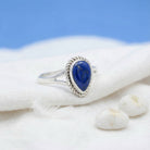 [KI] Silberring mit Lapislazuli auf hellem Stoff