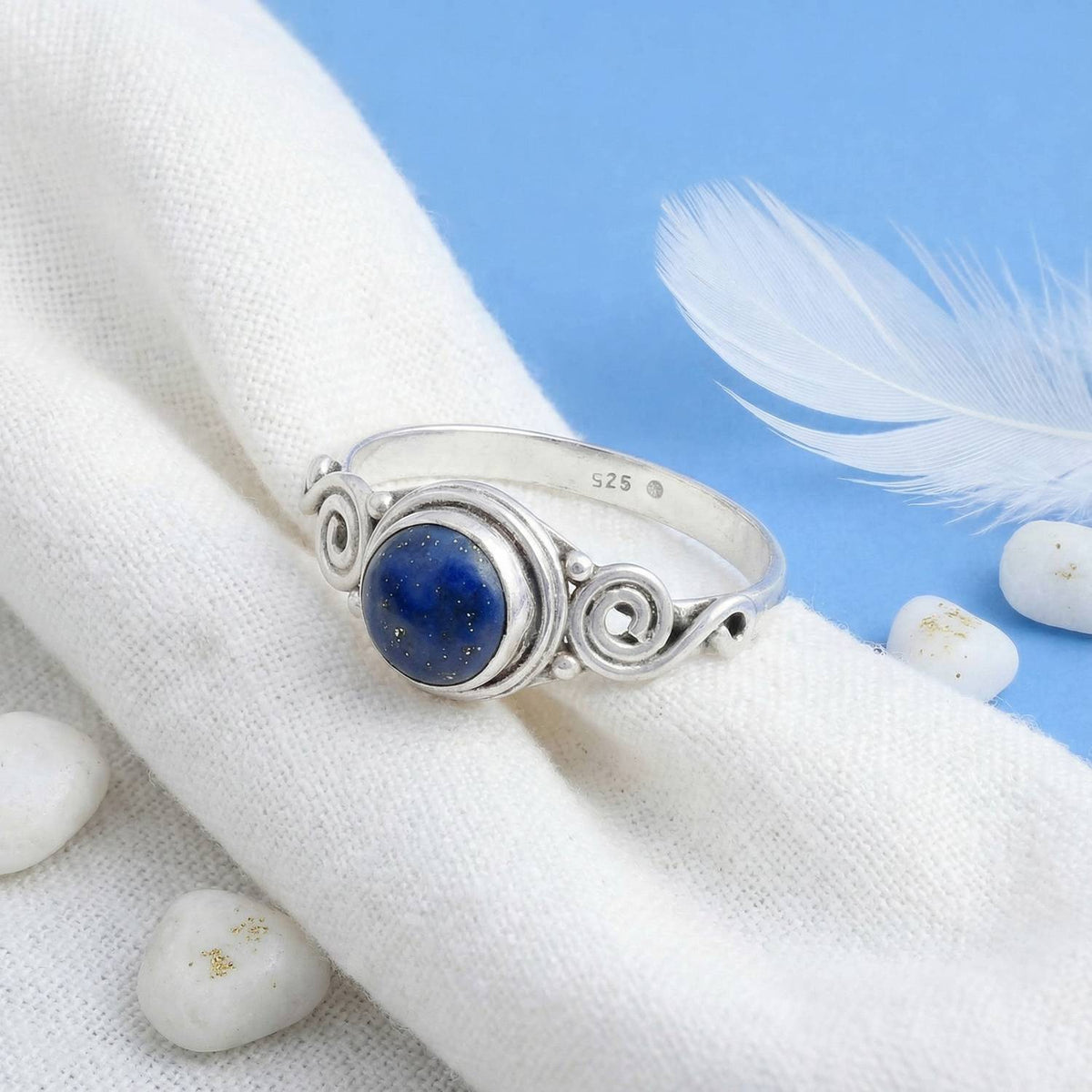 Silberring mit Lapislazuli auf hellem Stoff