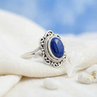 [KI] Silberring mit Lapislazuli auf hellem Stoff