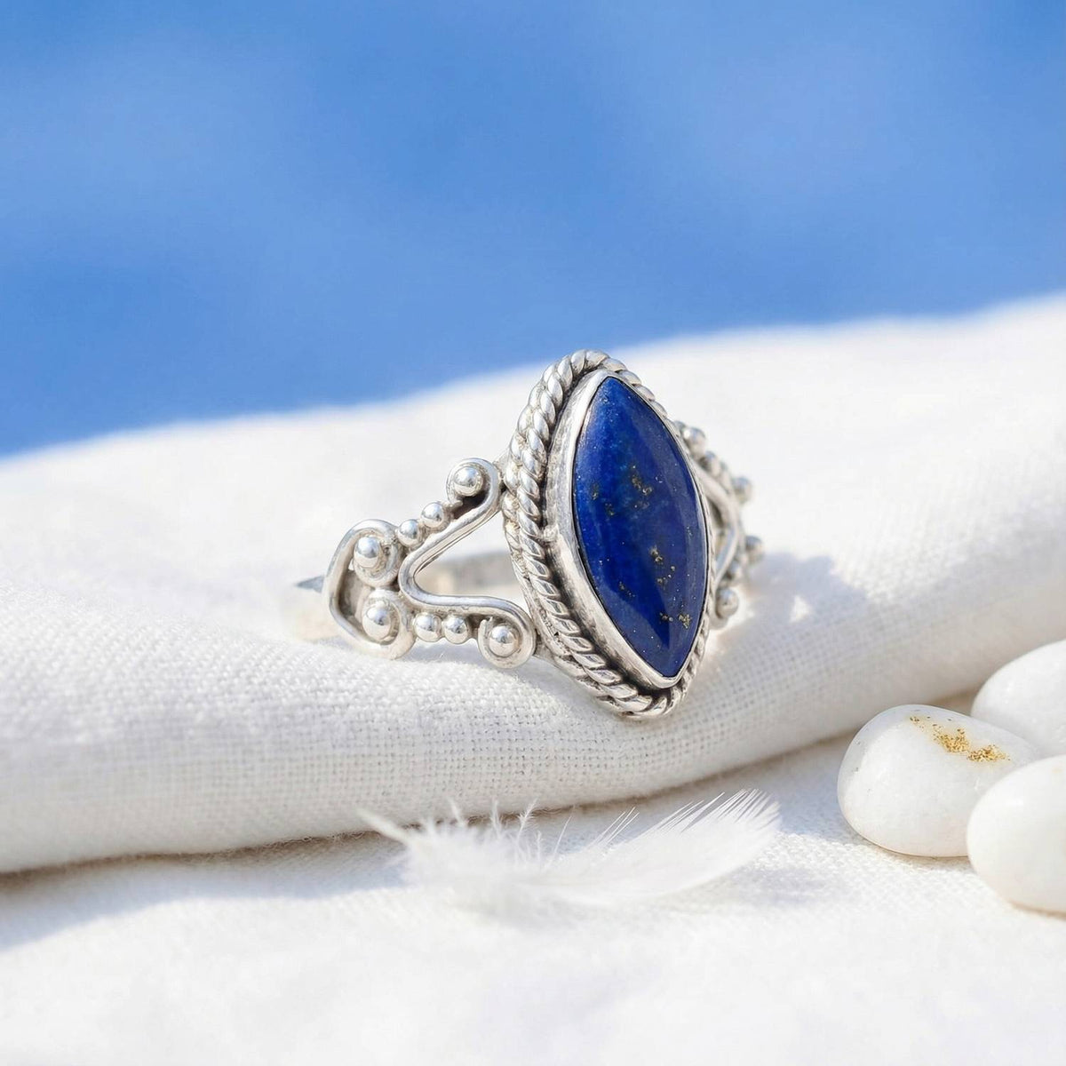 Silberring mit Lapislazuli auf hellem Stoff