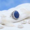 [KI] Silberring mit Lapislazuli auf hellem Stoff