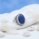 [KI] Silberring mit Lapislazuli auf hellem Stoff