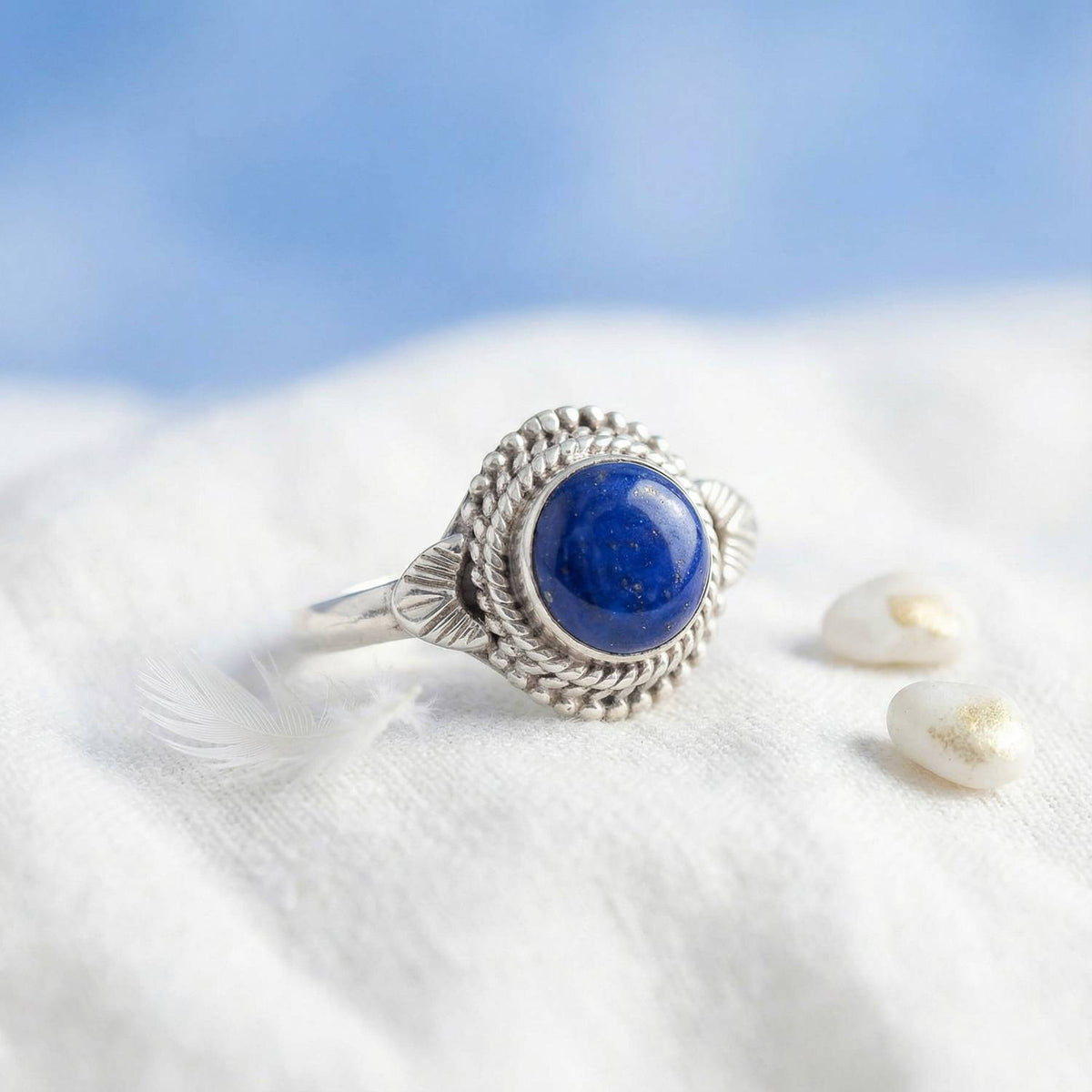 Silberring mit Lapislazuli auf hellem Stoff