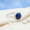 [KI] Silberring mit Lapislazuli auf hellem Stoff