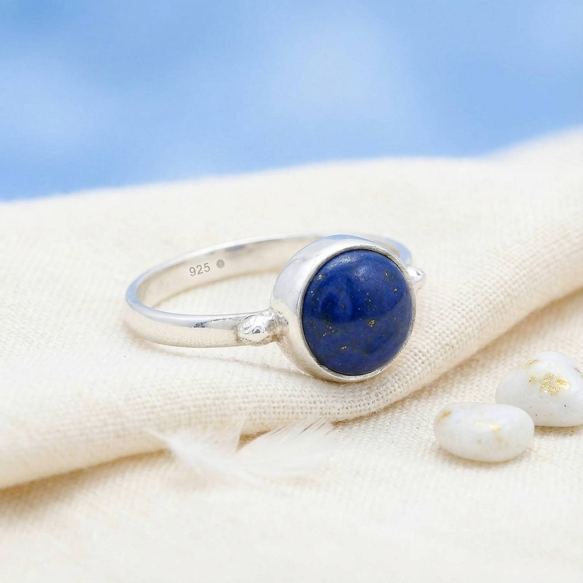 Silberring mit Lapislazuli auf hellem Stoff