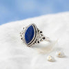 [KI] Silberring mit Lapislazuli auf hellem Stoff