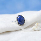 [KI] Silberring mit Lapislazuli auf hellem Stoff