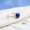 [KI] Silberring mit Lapislazuli auf hellem Stoff