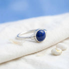 [KI] Silberring mit Lapislazuli auf hellem Stoff