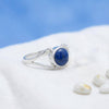 [KI] Silberring mit Lapislazuli auf hellem Stoff