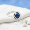 [KI] Silberring mit Lapislazuli auf hellem Stoff