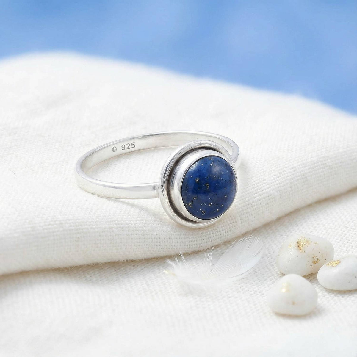 Silberring mit Lapislazuli auf hellem Stoff