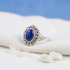 [KI] Silberring mit Lapislazuli auf hellem Stoff
