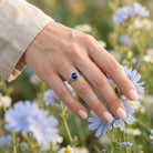 [KI] Silberring mit Lapislazuli an der Hand zwischen Blumen