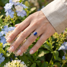 [KI] Silberring mit Lapislazuli an der Hand zwischen Blumen