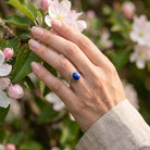 [KI] Silberring mit Lapislazuli an der Hand zwischen Blumen