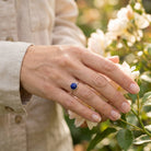 [KI] Silberring mit Lapislazuli an der Hand zwischen Blumen