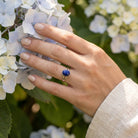 [KI] Silberring mit Lapislazuli an der Hand zwischen Blumen