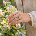 [KI] Silberring mit Lapislazuli an der Hand zwischen Blumen