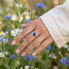 [KI] Silberring mit Lapislazuli an der Hand zwischen Blumen