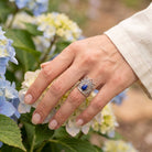 [KI] Silberring mit Lapislazuli an der Hand zwischen Blumen