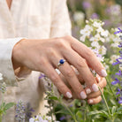 [KI] Silberring mit Lapislazuli an der Hand zwischen Blumen