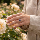 [KI] Silberring mit Lapislazuli an der Hand zwischen Blumen