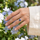 [KI] Silberring mit Lapislazuli an der Hand zwischen Blumen
