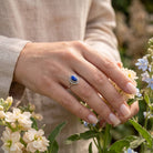 [KI] Silberring mit Lapislazuli an der Hand zwischen Blumen