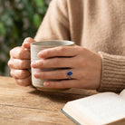 [KI] Lapislazuliring aus Silber getragen beim Lesen mit einer Tasse