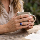 [KI] Lapislazuliring aus Silber getragen beim Lesen mit einer Tasse