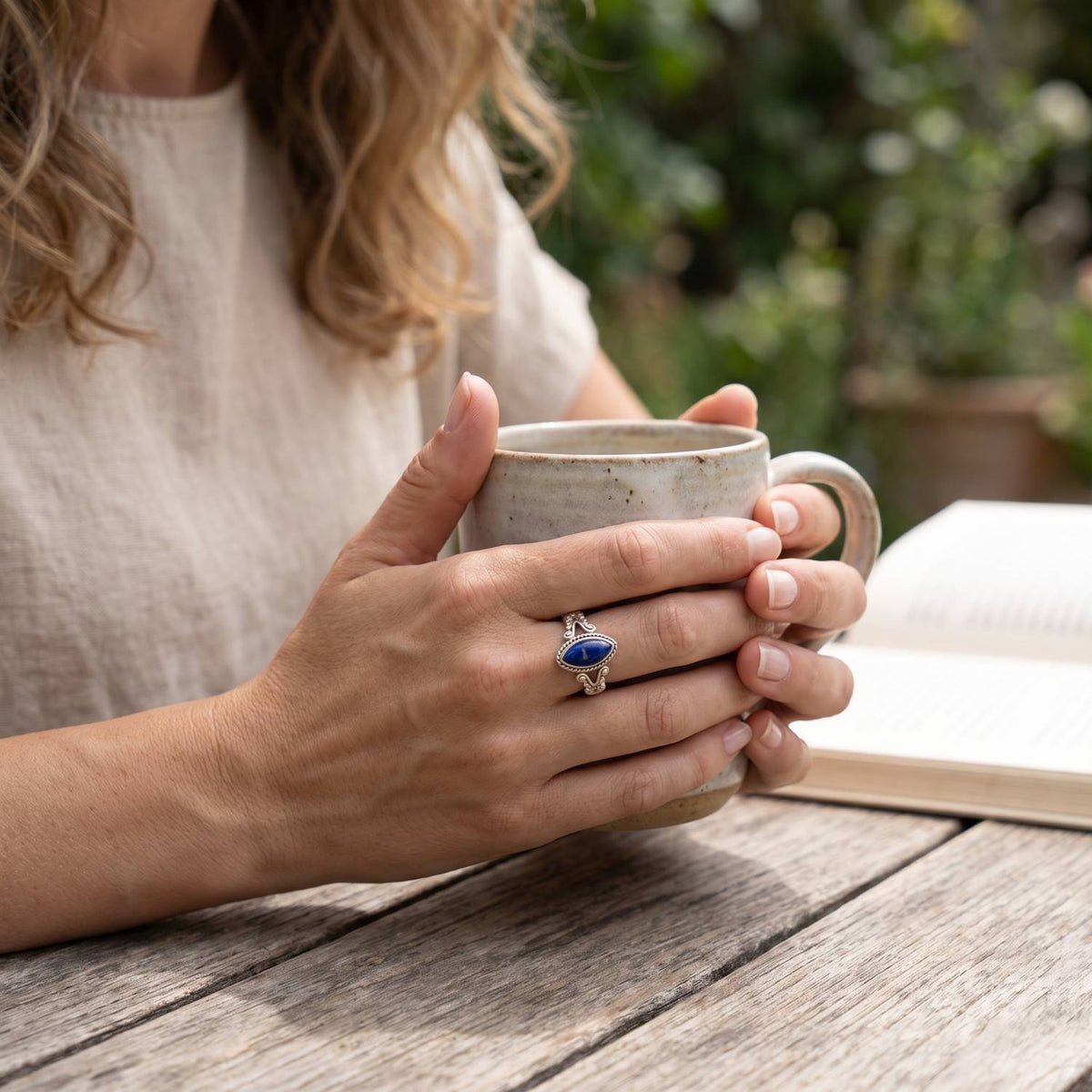 Lapislazuliring aus Silber getragen beim Lesen mit einer Tasse