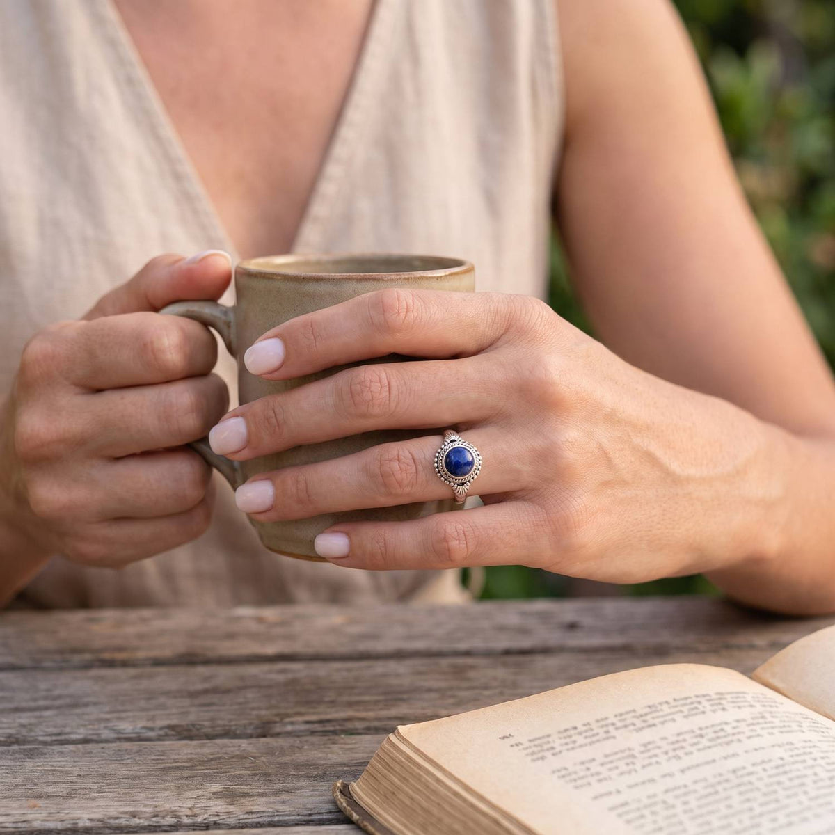Lapislazuliring aus Silber getragen beim Lesen mit einer Tasse