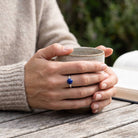 [KI] Lapislazuliring aus Silber getragen beim Lesen mit einer Tasse