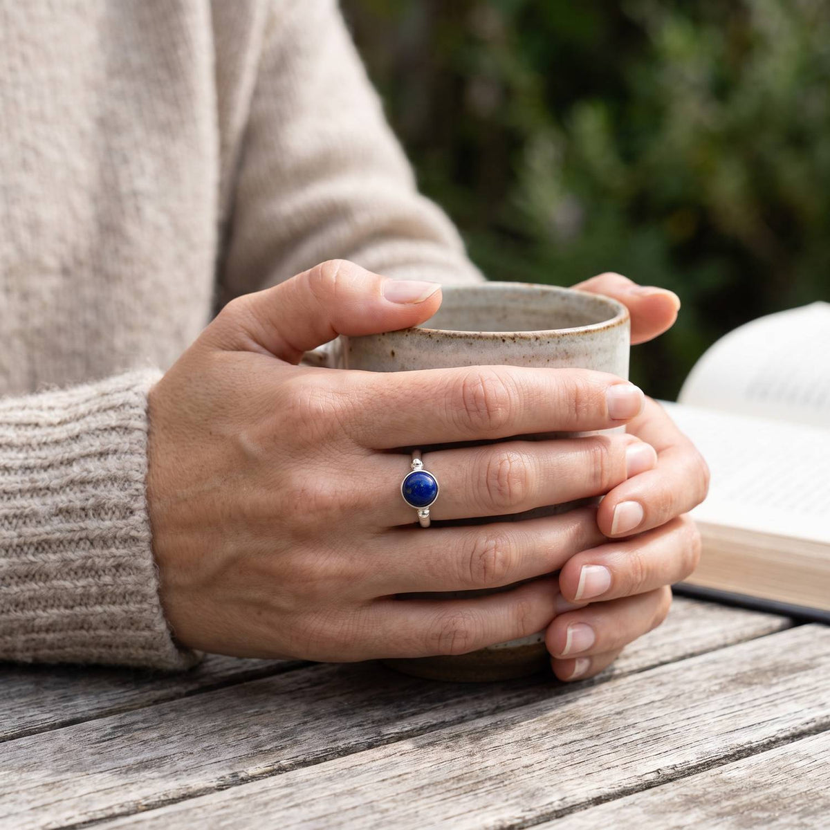 Lapislazuliring aus Silber getragen beim Lesen mit einer Tasse