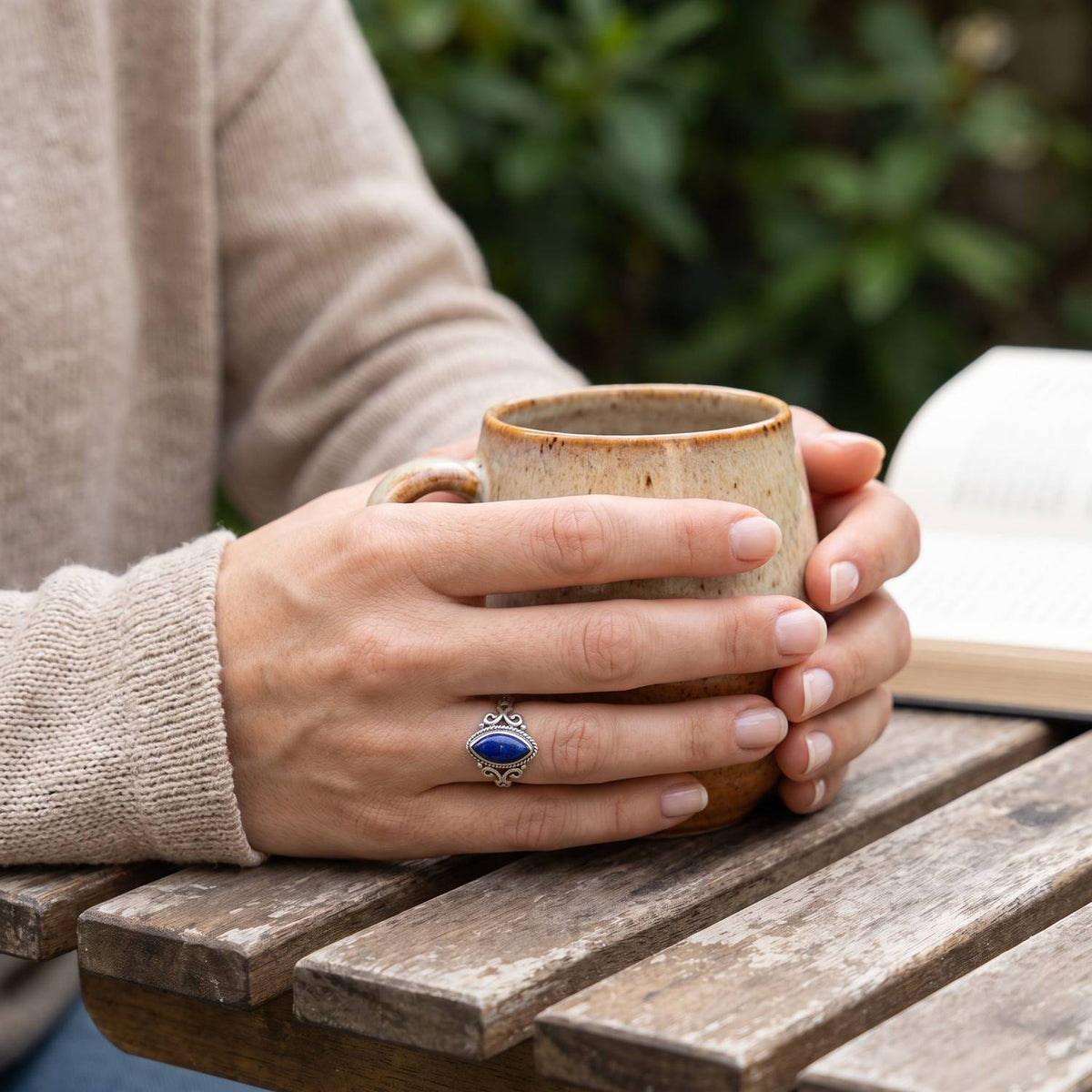 Lapislazuliring aus Silber getragen beim Lesen mit einer Tasse