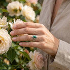 [KI] Silberring mit Malachit an der Hand zwischen Blumen