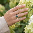 [KI] Silberring mit Malachit an der Hand zwischen Blumen