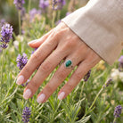 [KI] Silberring mit Malachit an der Hand zwischen Blumen