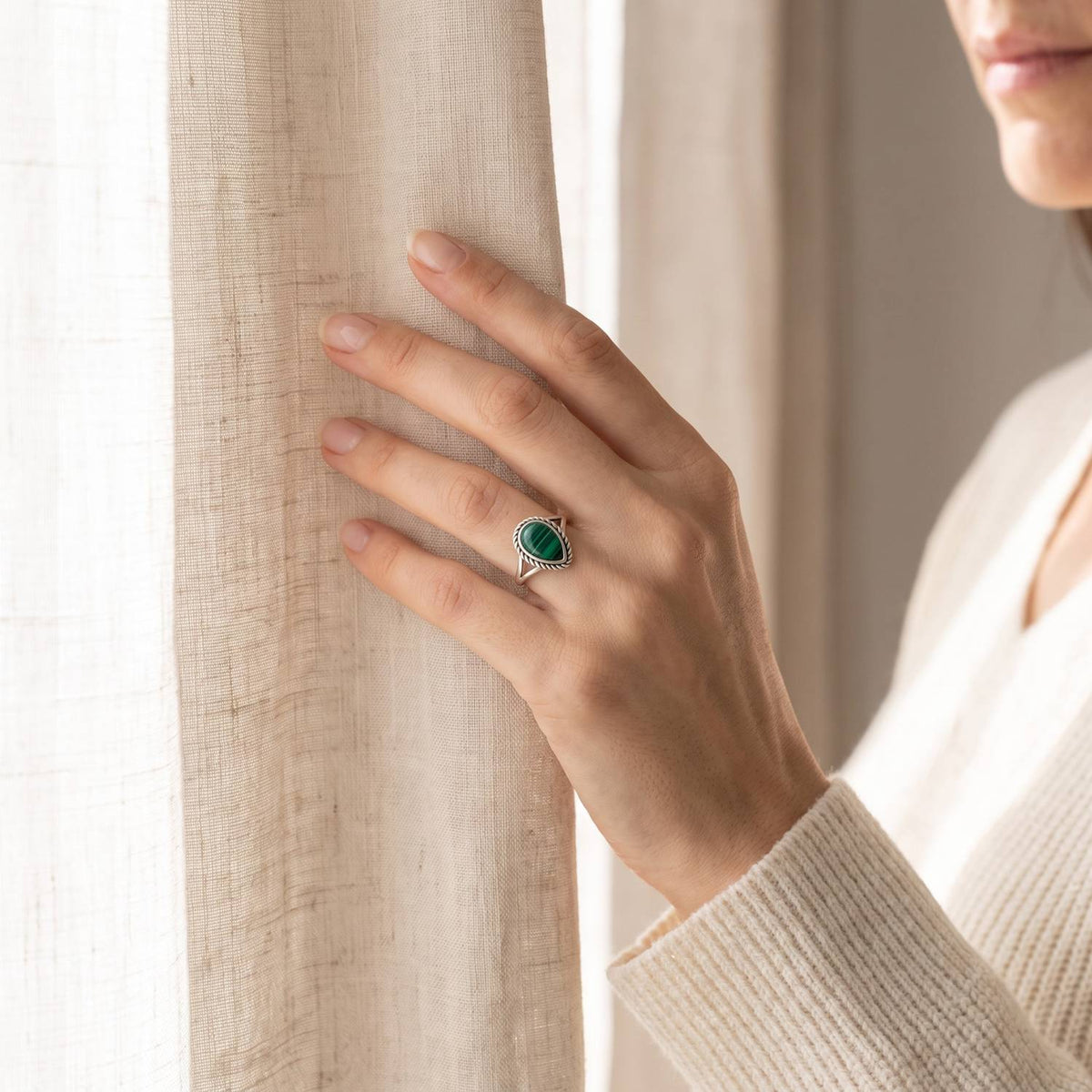 Frau trägt einen Malachitring aus Silber am Fenster