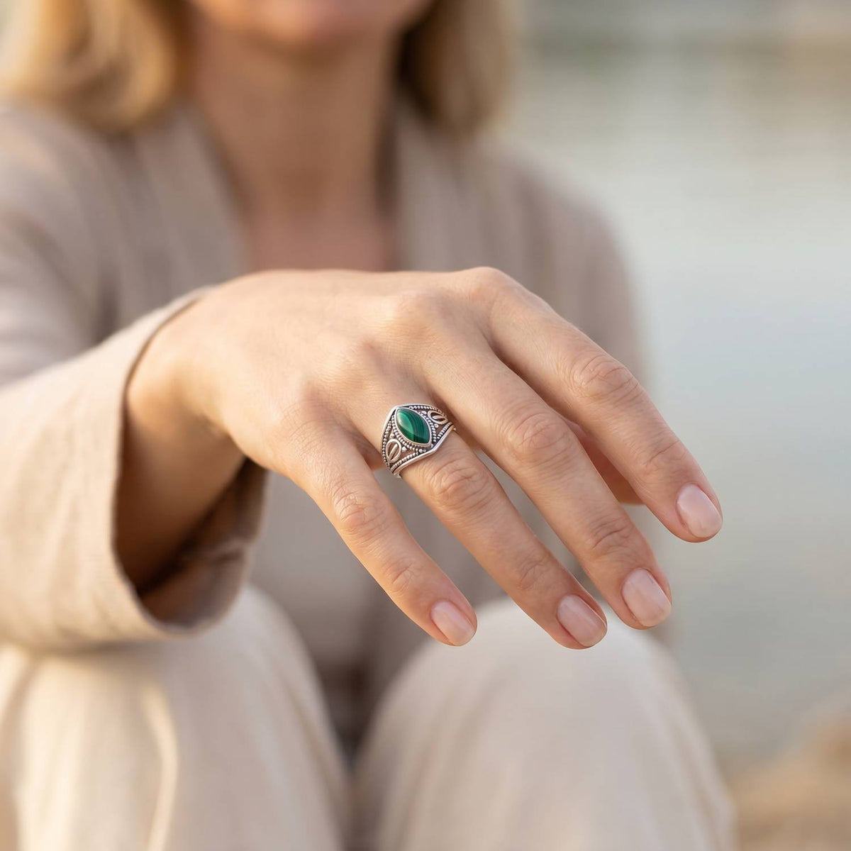 Malachitring aus Silber getragen an der Hand im Freien
