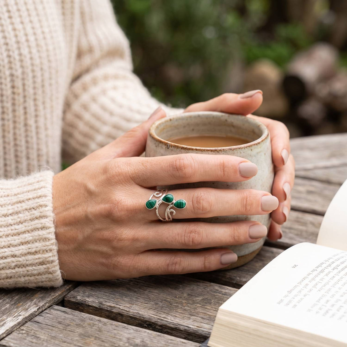 Malachitring aus Silber getragen beim Lesen mit einer Tasse
