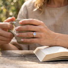 [KI] Mondsteinring aus Silber getragen beim Lesen mit einer Tasse