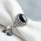 [KI] Silberring mit Onyx auf hellem Stoff