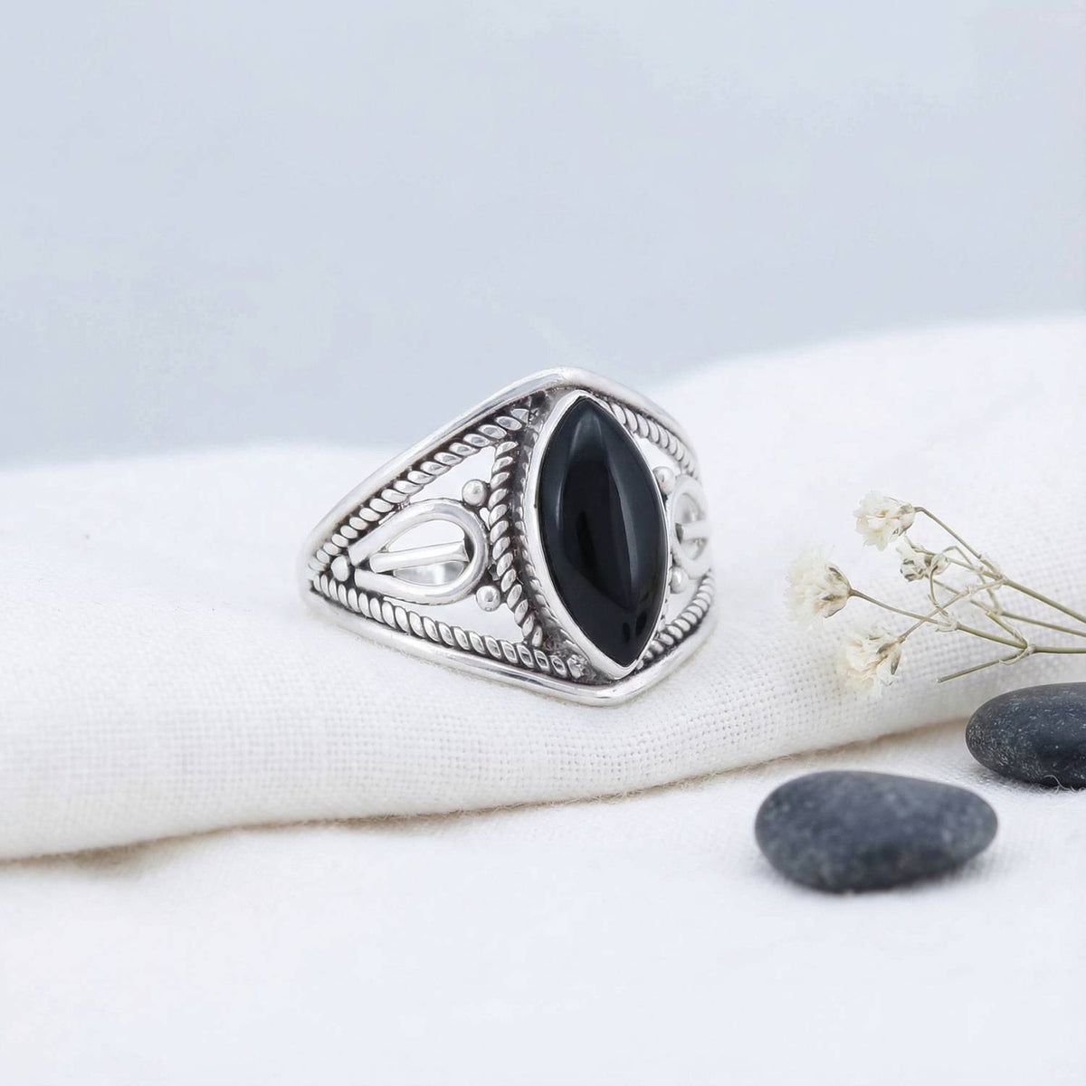 Silberring mit Onyx auf hellem Stoff