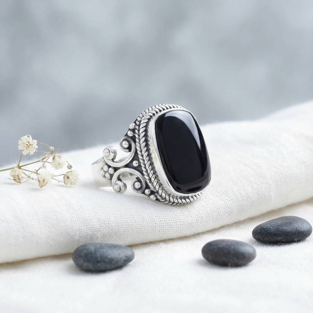 Silberring mit Onyx auf hellem Stoff